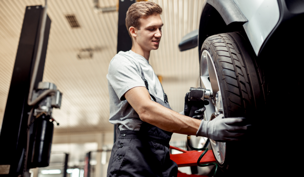 An auto mechanic changes a tire while at work at a car repair service