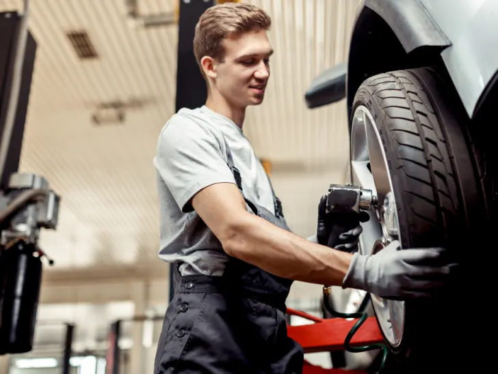 An-automechanic-changes-a-tire-while-at-work-at-a-car-repair-service