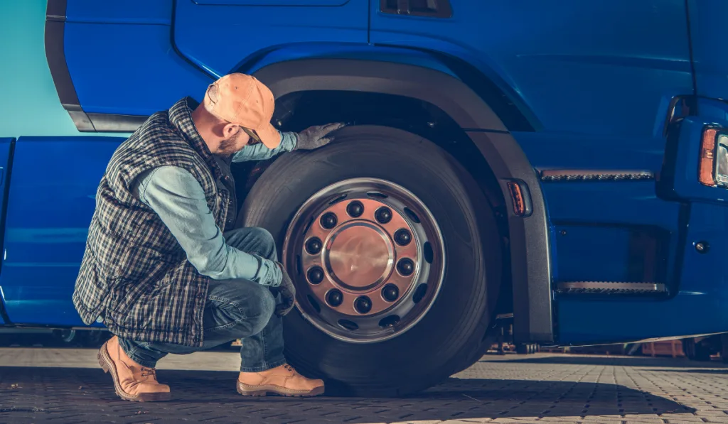 driver checking Semi Truck Wheels 