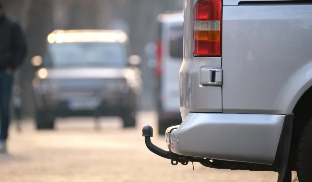 Close up of a van with tow hitch parked on city street side 