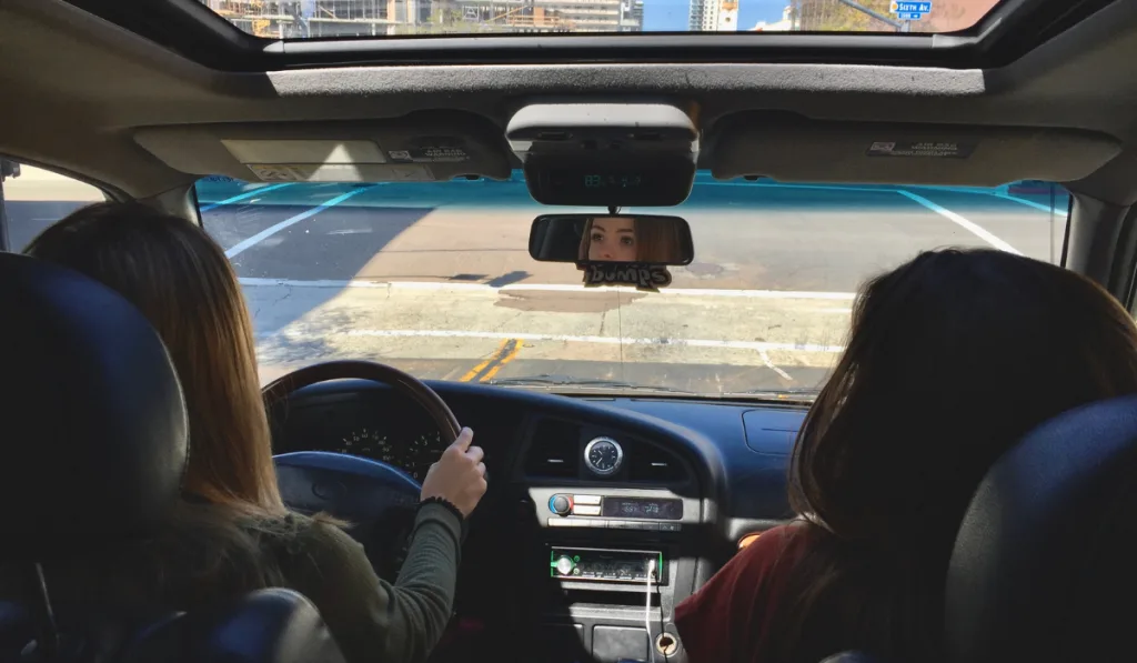 female driving a pickup truck with opened sunroof