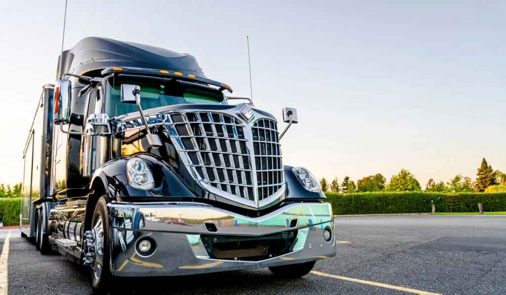 Shiny black semi-truck on parking area 