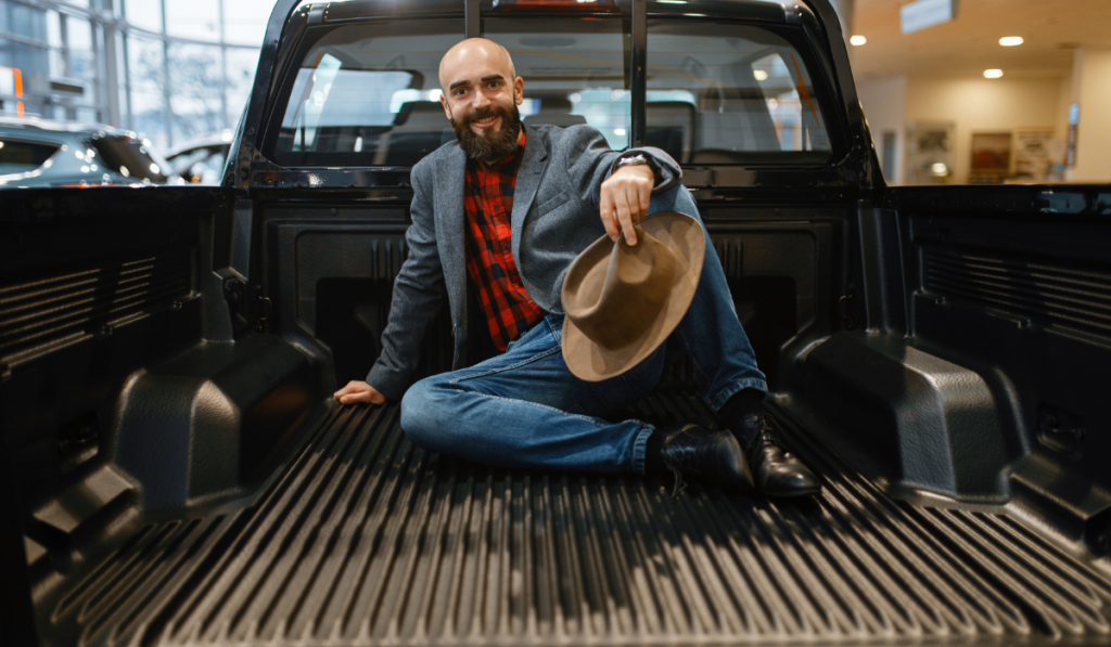 Smiling man poses in the back of new pickup truck