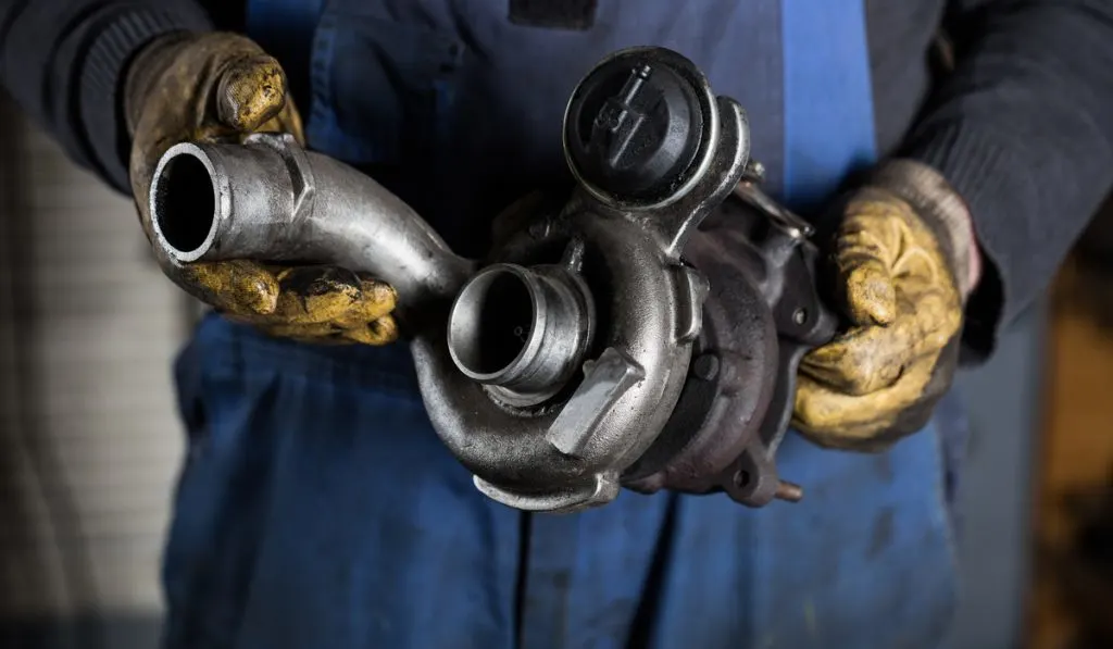 auto mechanic holding used truck turbo