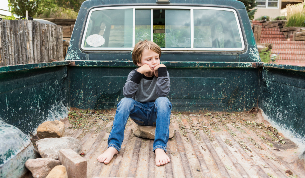 boy posing in the bed of an old pick up truck