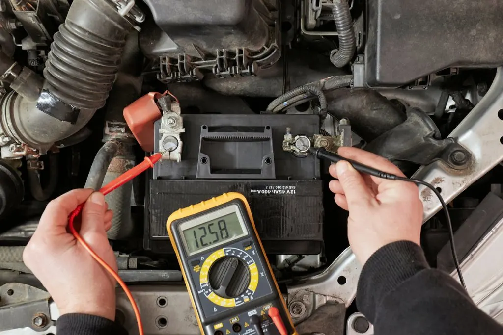 man checking battery voltage using multimeter 