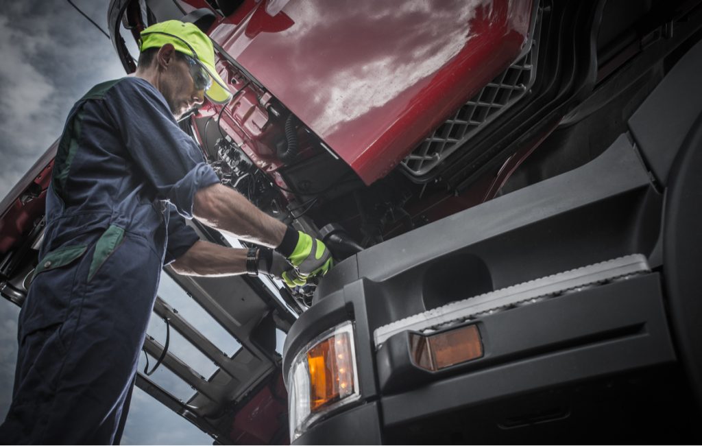 professional mechanic servicing semi-truck 