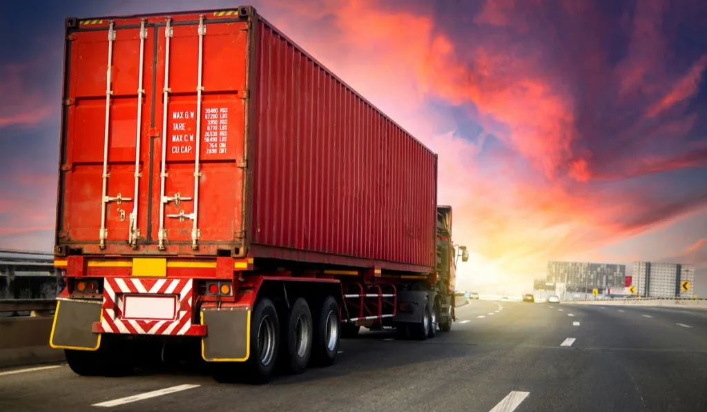 red cargo truck on highway purple cloud