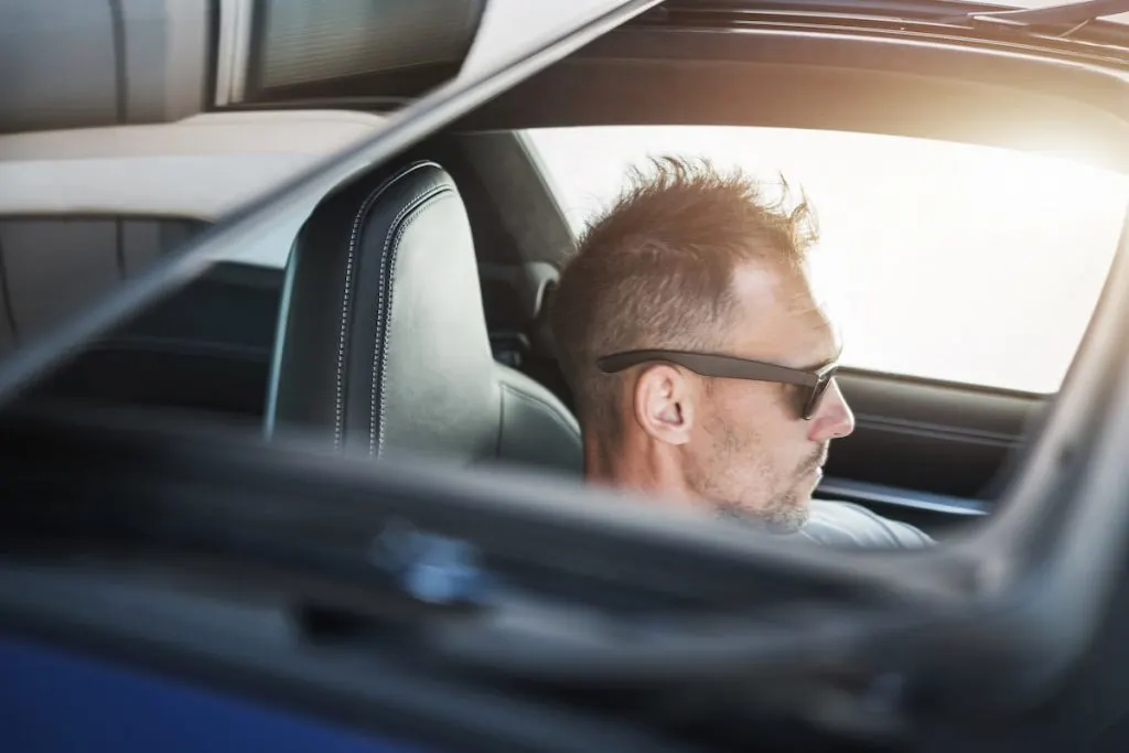 man driving a pickup truck with opened sunroof during summer