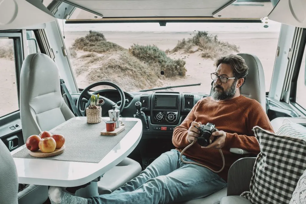 One man sitting and relaxing inside a vehicle facing his work station