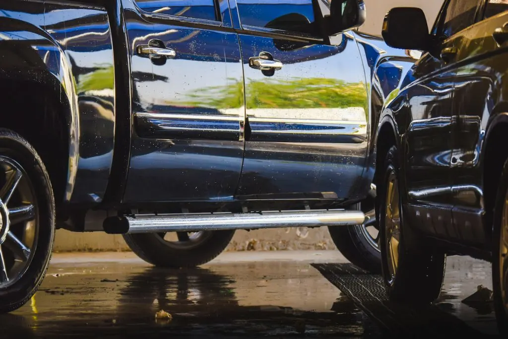 black pickup truck and black car in a garage